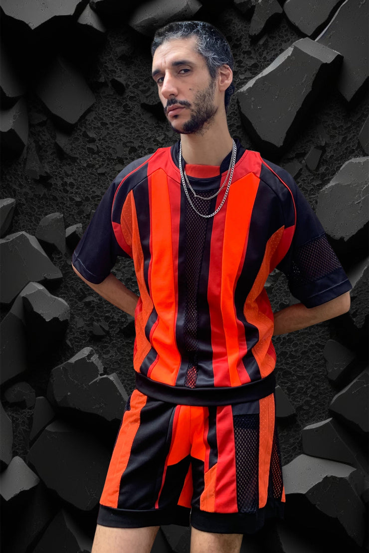 ensemble maillot et short upcyclé football rouge orange noir porté par un beau brun bruxellois