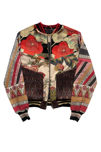 veste bomber réversible en patchwork de tissus artisanaux asiatiques et européens avec des motifs géométriques et floraux. Non portée, sur fond blanc.